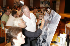 Mme Noah signe une affiche à M. Del Giglio pour son fondation. Yakaprint a organisé la réception pour le passage du Tour de France à Sedan
